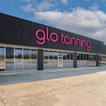 Parking lot and the storefront of a Glo Tanning salon in Paragould.