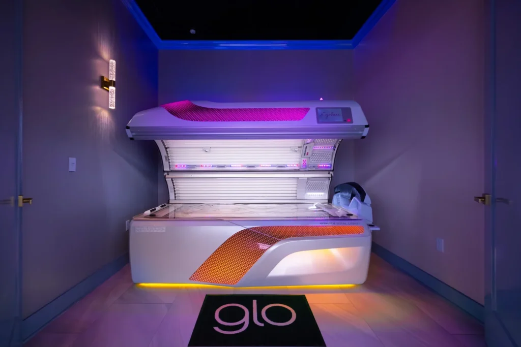 An open tanning bed, glo-styled rug and a wall lamp.