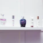 A shelf with various 'glo' tanning and skincare products, including bottles labeled 'Indulge' and 'skin by glo.