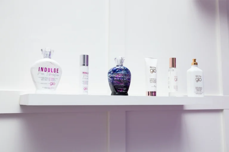 A shelf with various 'glo' tanning and skincare products, including bottles labeled 'Indulge' and 'skin by glo.